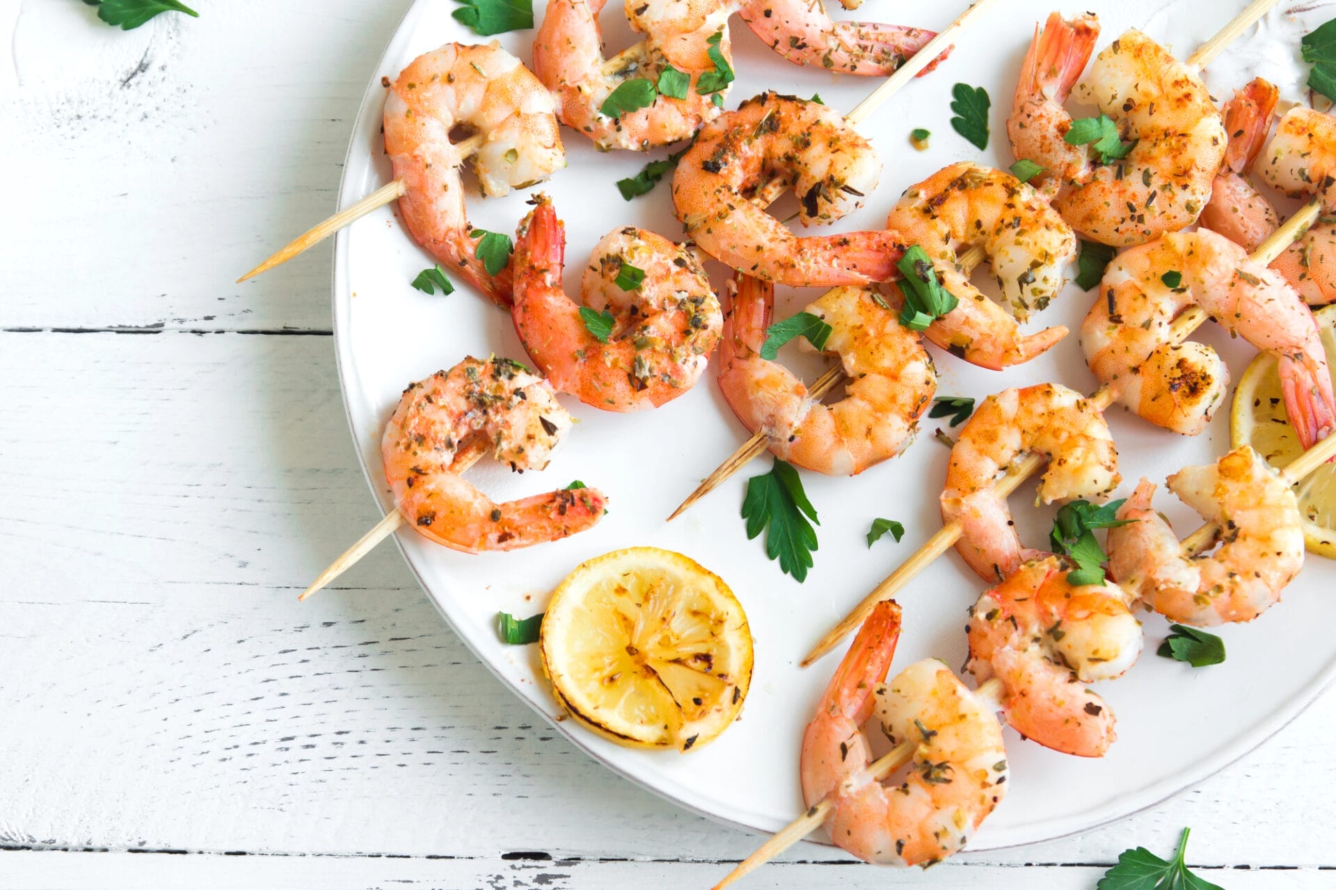 Grilled shrimp skewers with herbs and lemon slice